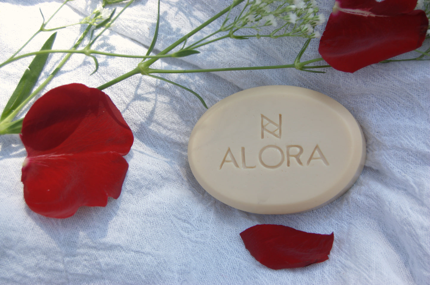 Goat milk soap with rose petals surrounding.